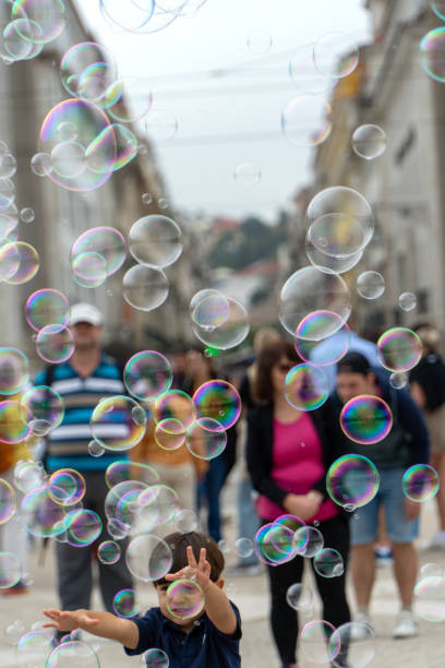 Soap bubbles float in the air in the Praça do Comércio as tourists and locals alike enjoy the busy summer streets of Lisbon the capitol city of Portugal. June 28th 2024