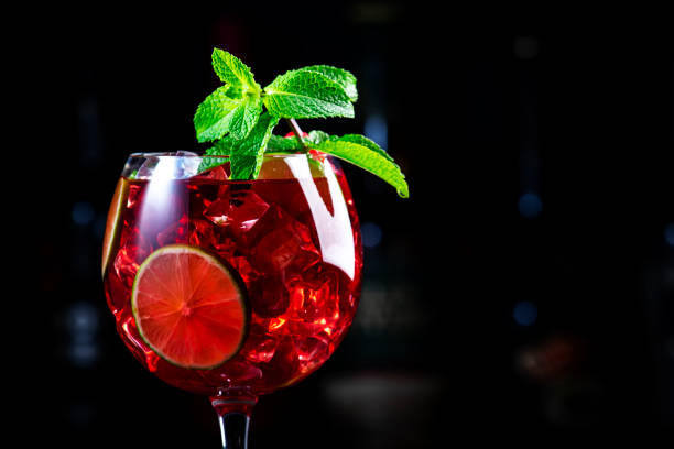 istock Raspberry lemonade cocktail drink with tequila, gin, rum, vodka, liquor, lime, fresh raspberries and ice. Black bar counter background 2160508780