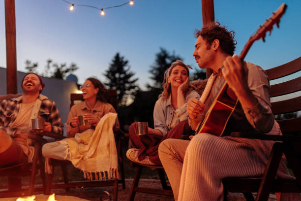istock Friends enjoying and laughing by the fire 2160509357