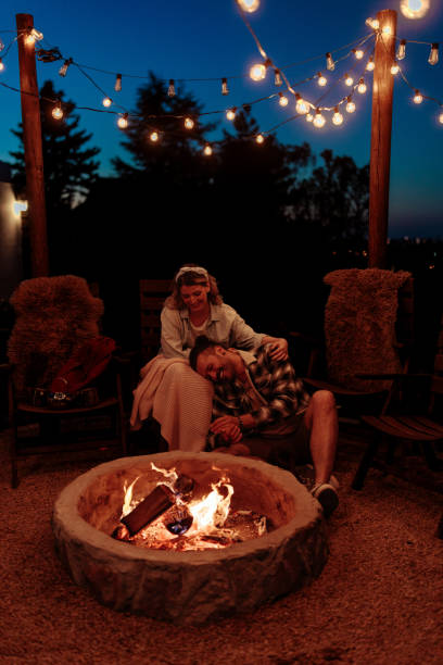 istock Couple relaxing by outdoor fire pit 2160509367
