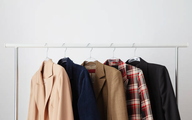 several women's jackets on a hanger on a white background