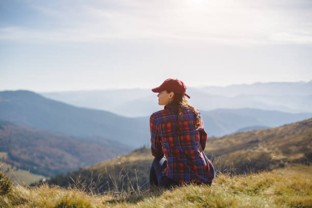 istock Woman Relaxing on Grass with Stunning Mountain Panorama 2160515468