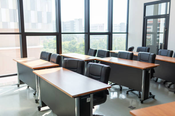istock Empty classroom with table and chairs for lecture or seminar in university. 2160518479