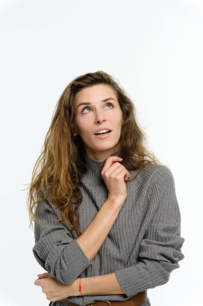 istock Young woman with a dreamy expression on her face. White background. 2160521226