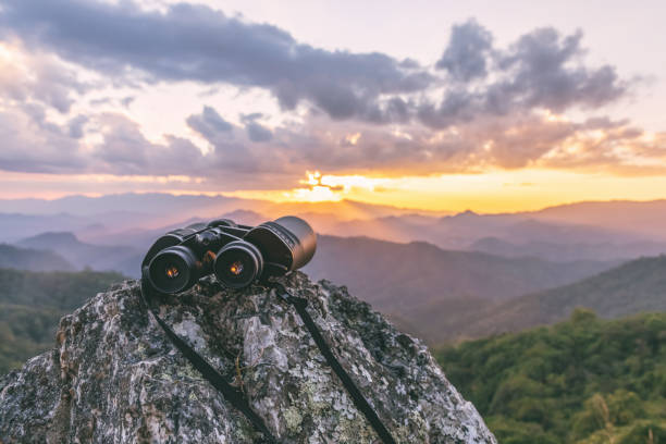 istock binoculars on top of rock mountain at sunset 2160522594