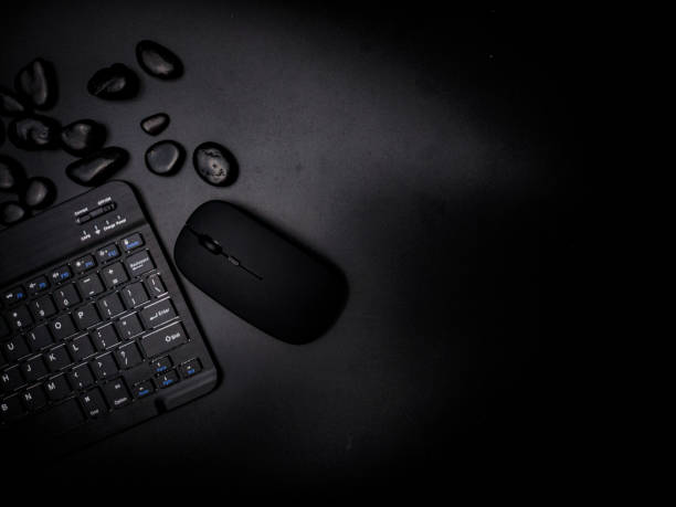 istock A black wireless keyboard and mouse with black stone on a black background. 2160529003