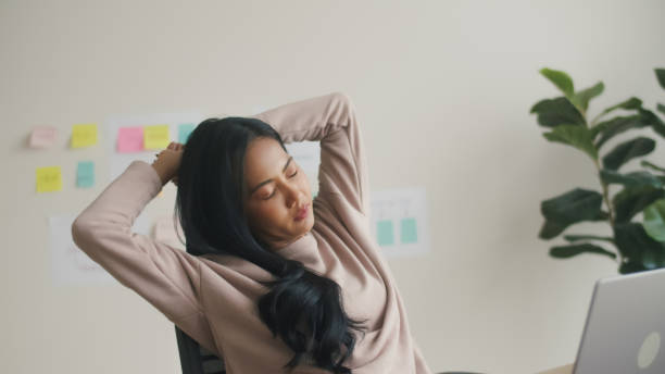 istock Young female stretched her arm while working at the desk in the office. 2160531820