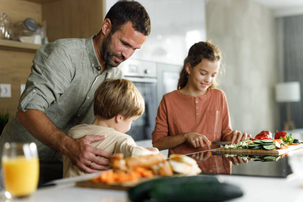 istock Smiling single father and his kids preparing a meal in the kitchen. 2160534711