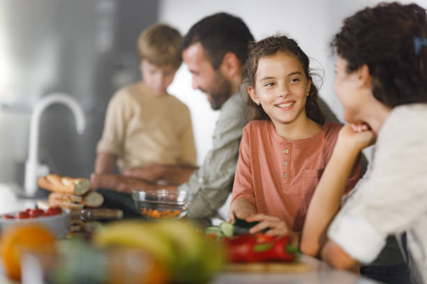 istock Family cooperating while making a meal in the kitchen. 2160535128