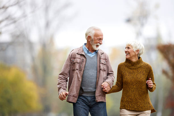 istock Playful senior couple having fun while running in the park. 2160535321