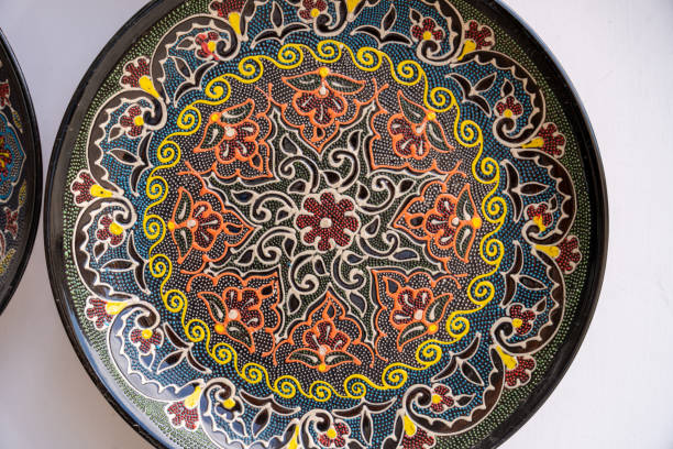 A colorful plate with a flower design on it. The plate is black and white with a yellow flower in the center