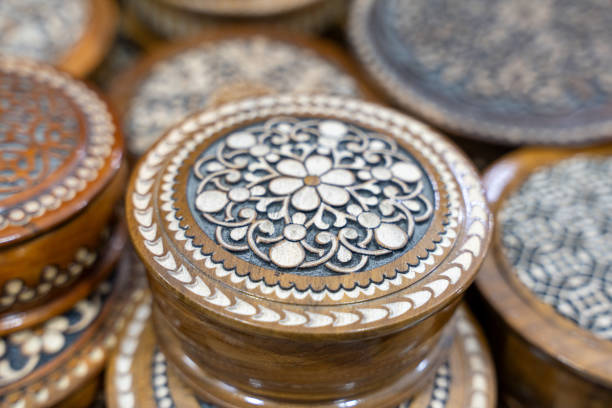 A collection of wooden boxes with intricate designs on them. The boxes are arranged in a pile, with some of them being taller than others. Scene is one of elegance and sophistication