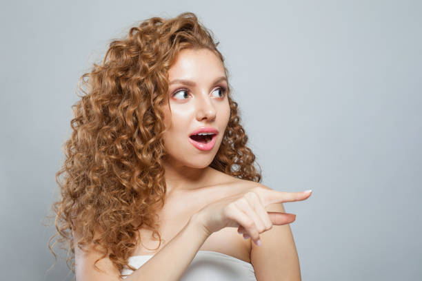 istock Surprised woman pointing finger on white background with copy space 2160538204