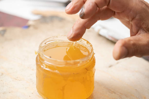 istock Shoe Craftsman Applying Glue to Shoe Sole 2160538304