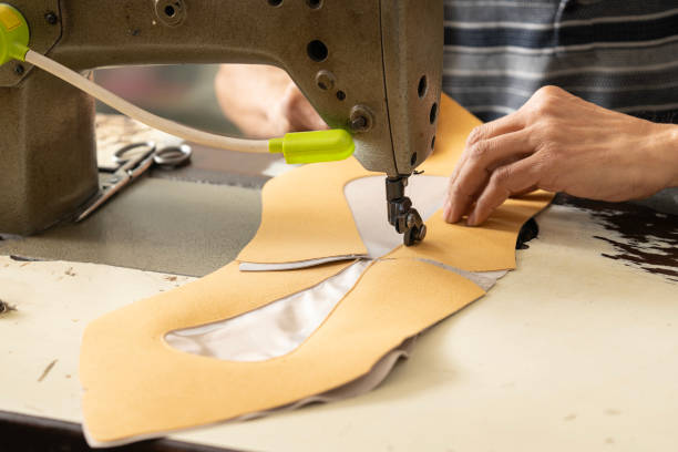 istock Craftsman Sewing Shoe Parts on a Sewing Machine 2160538401