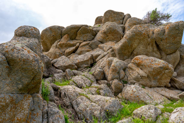 A rocky hillside with a few small rocks scattered around. The rocks are mostly grey and brown in color