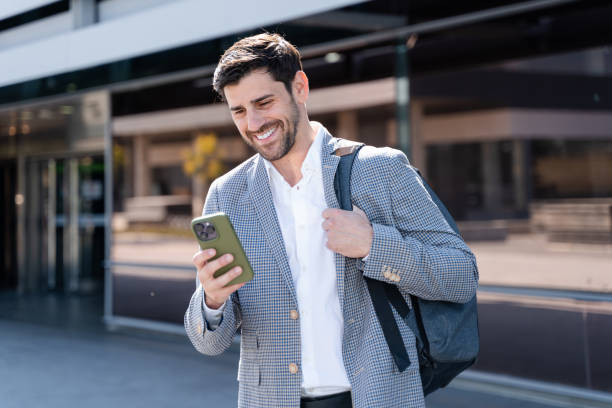 istock businessman using smartphone app walking outside office building 2160544685