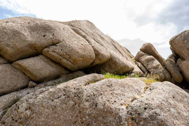A rocky hillside with a few small rocks scattered around. The rocks are mostly grey and brown in color