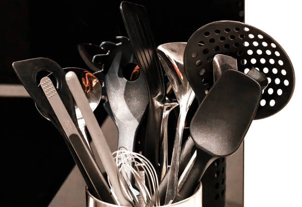 istock Kitchen utensils in containers in kitchen. Strainer Spoon, Spaghetti Server, Slotted Tourner, Salad Fork Spoon, Spatula, Metallic Spoon against black and white background. 2160545319