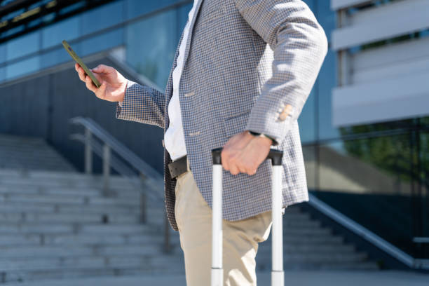 istock Businessman using smartphone holding suitcase outside office building 2160545392