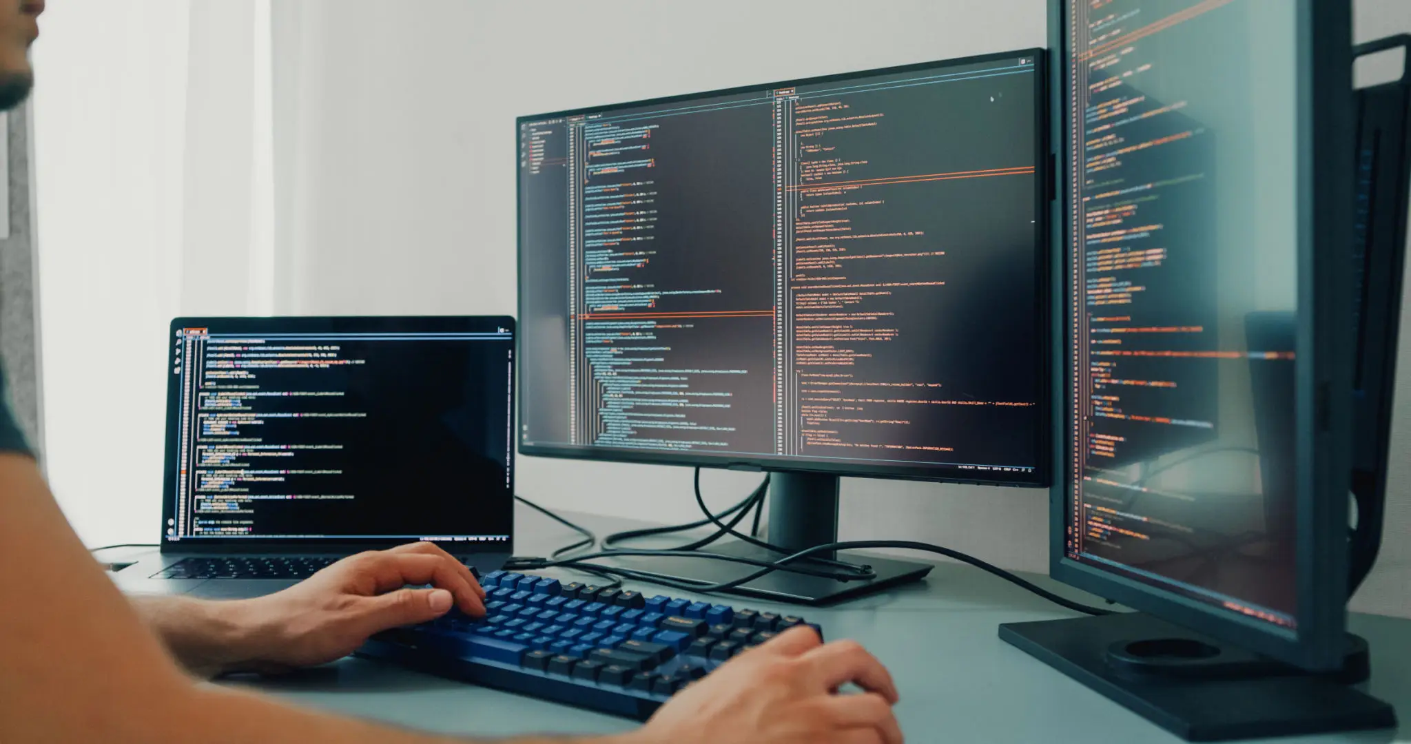 컴퓨터와 함께하는 JavaScript 언어의 힘 2 Closeup young man software developers using computer to write code application program for AI technology development at desk with multiple screens work at home office. Programmer development.
