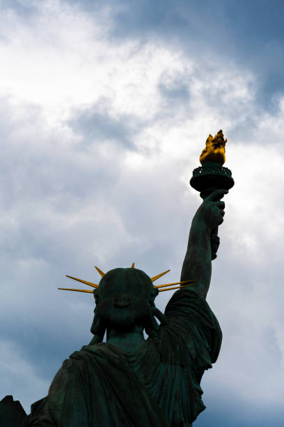 istock Statue of Liberty facing a sky of storm clouds 2160545593