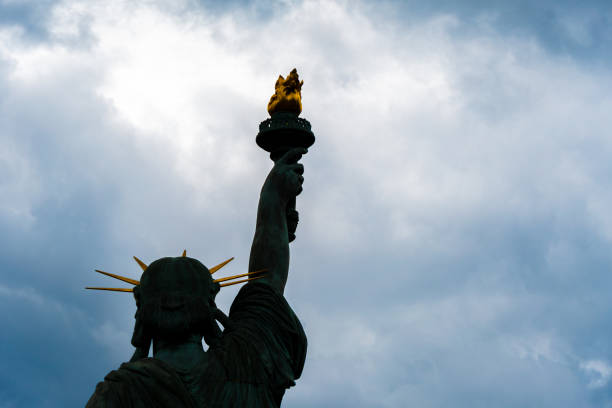 istock Statue of Liberty facing a sky of storm clouds 2160545596