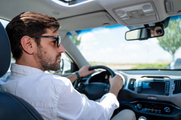 istock Businessman driving modern car on sunny day 2160545670