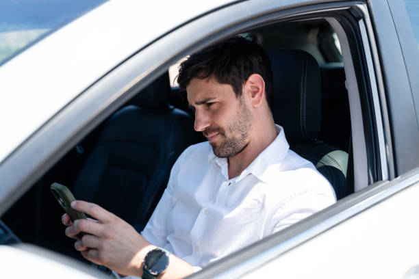 istock Businessman sitting in car checking his phone 2160545729