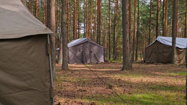 istock Scout Group Summer Camp Tarpaulin Tarp Canvas Tent Shelters Deployed in Forest 2160545979