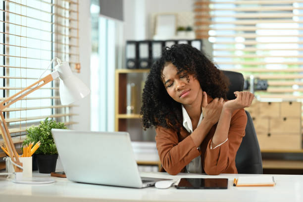 istock businesswoman suffering from neck pain while after long hours work. 2160549997