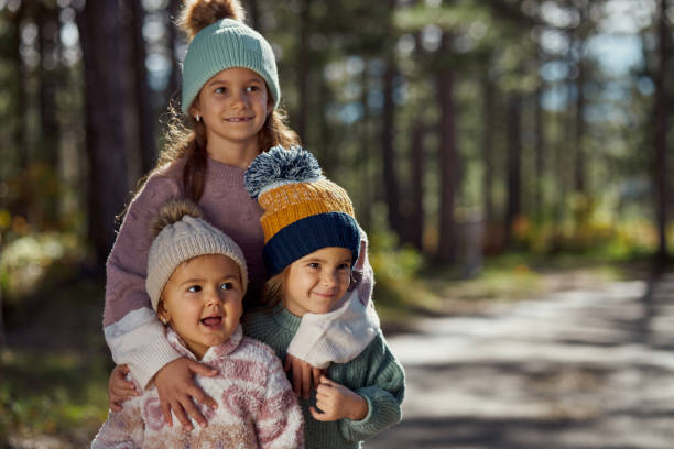 Portrait of happy children in sunny forest.