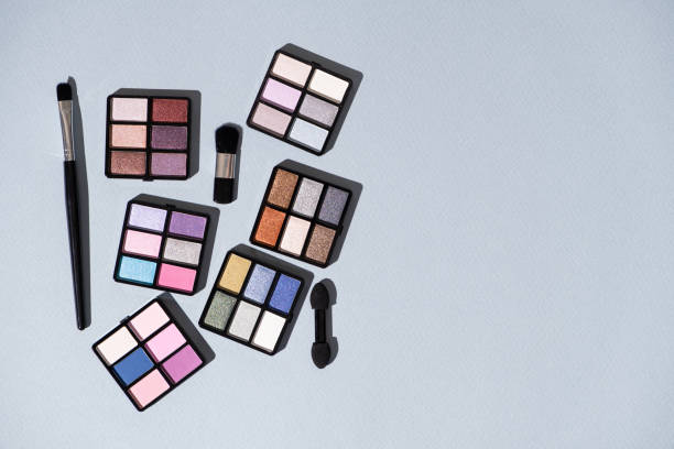 istock A set of multi-colored eyeshadow and brushes on a blue background. Eye makeup 2160564055