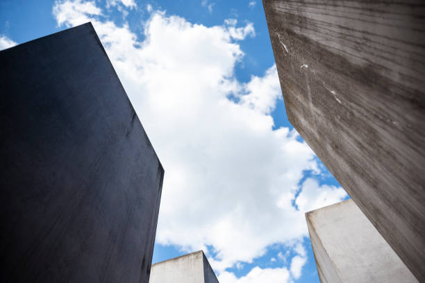 Berlin, Germany - April 27, 2024: Looking up into the sky with clouds at the Holocaust Memorial in Berlin.