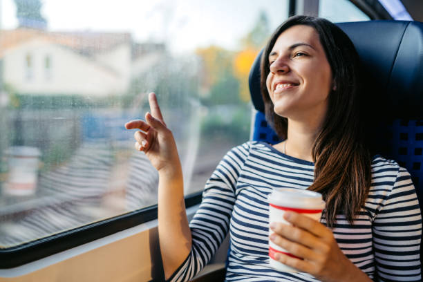 istock Young Woman Drinking Coffee While Riding In A Train Through Lubeck In Germany 2160567636