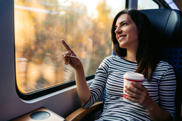 istock Young Woman Drinking Coffee While Riding In A Train Through Lubeck In Germany 2160567716