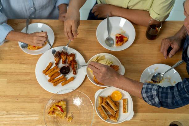 istock Hands of three people during eating meal on table 2160571277