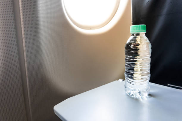 istock Bottled mineral water on table next to airplane cabin window 2160571803
