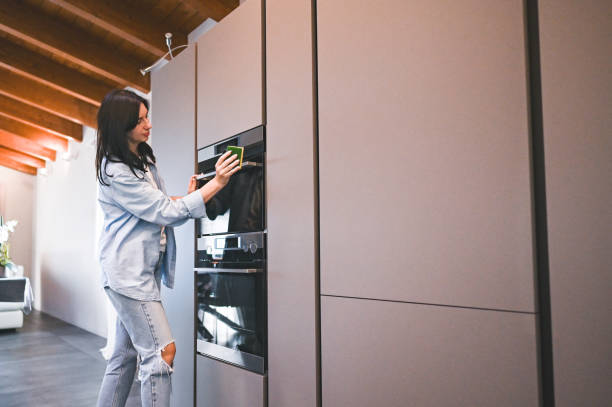 istock Young woman cleaning modern kitchen with sponge. 2160573402