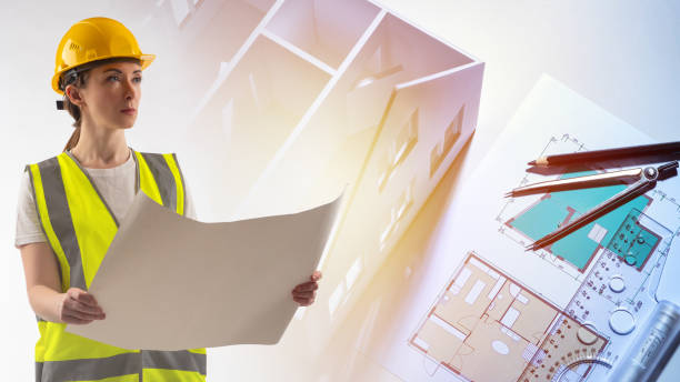 istock Construction design. Woman architect with paper drawing in her hands. Engineer on the background of drawings and house mock-up. Architectural and construction bureau. Construction projects. 2160573724