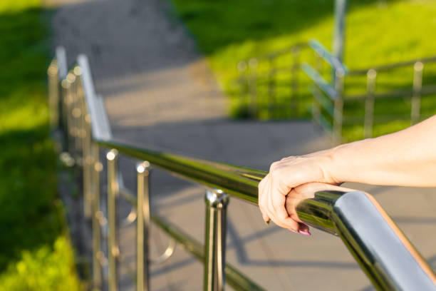 istock woman's hand holding onto the metal staircase railing. 2160574217