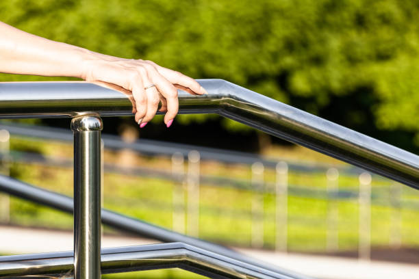 istock woman's hand holding onto the metal staircase railing 2160574281