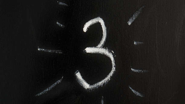 Close-up of three-dimensional red number 3 on white background.
