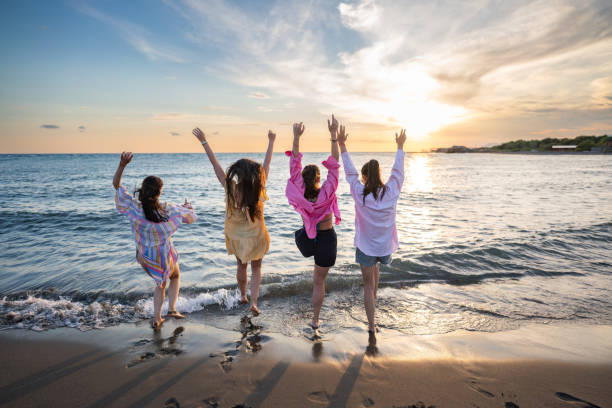 istock Playful female friends having fun on the beach 2160574601