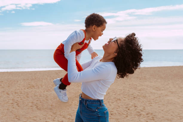 istock Young mother enjoys with daughter at beach 2160575678