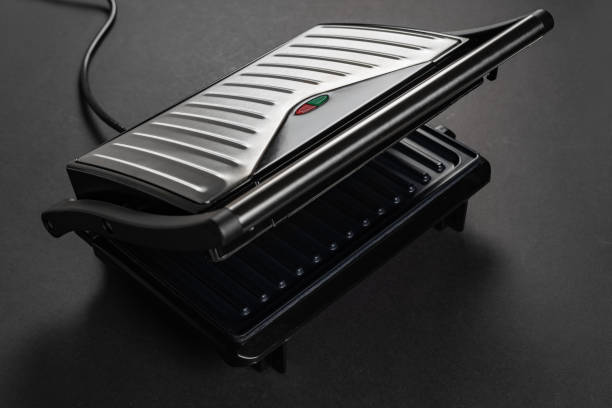 istock Modern electric grill on dark background. Fried meat and boiling fat 2160575982
