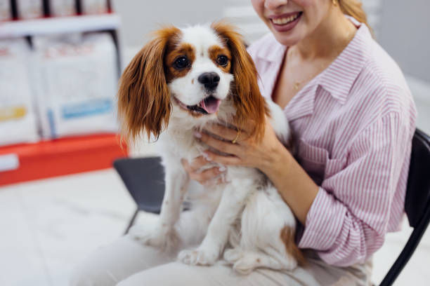 istock Woman Smiling While Holding Her Adorable Dog Inside a Pet Store 2160576586