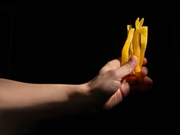 istock dried cantaloupe sticks in hand on black 2160578825