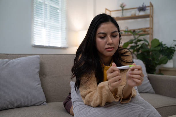 istock Sad unhappy woman holding a pregnancy test 2160579015