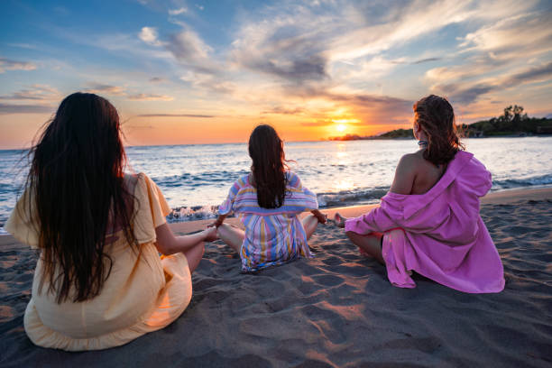istock Female friends relaxing on beach 2160582552